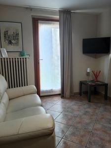 a living room with a couch and a sliding glass door at ATHENA Home Asti in Asti