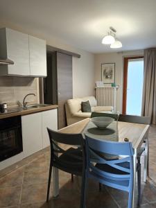a kitchen and living room with a table and chairs at ATHENA Home Asti in Asti