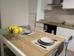 a table with a bowl of fruit and wine glasses at ATHENA Home Asti in Asti +20 photos