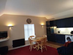a kitchen with a table and chairs and a clock on the wall at Aran View Loft in Knockfin Cross Roads