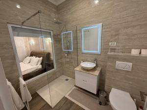 a bathroom with a shower and a sink and a bed at Apartament Centru Wot Diamond in Arad +12 photos