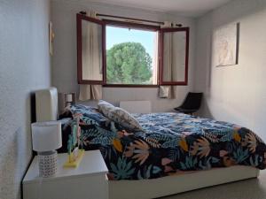 a bedroom with a bed with a colorful blanket and a window at Gîte Les hauts de Lenaly in Les Vans +28 photos
