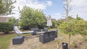 a patio with a swing and chairs in a yard at Villa Coubertin in La Rivière-de-Corps