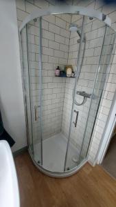 a shower with a glass door in a bathroom at Harrys Hideaway Cottage in Haworth +22 photos