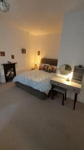a bedroom with a bed and a desk with a mirror at Harrys Hideaway Cottage in Haworth