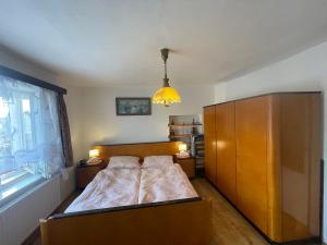 a bedroom with a bed and a large wooden cabinet at Chalupa Besednice in Besednice +33 photos