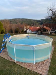 a large swimming pool in a yard with a ladder at Chalupa Besednice in Besednice