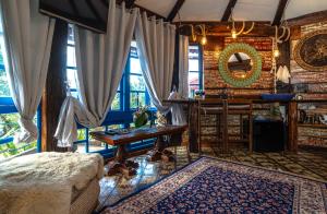 a living room with a table and some curtains at OctoCabana com banheira e mirante privativo in Urubici