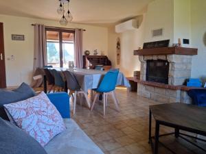 a living room with a table and a fireplace at Gîte Les hauts de Lenaly in Les Vans