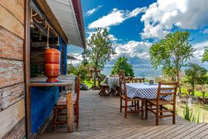 a wooden deck with a table and chairs at OctoCabana com banheira e mirante privativo in Urubici