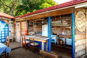 a wooden house with a table and chairs on a deck at OctoCabana com banheira e mirante privativo in Urubici