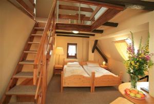 a bedroom with a bed and a wooden staircase at Hotel Zelený Dům in Boží Dar