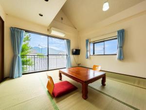 a room with a table and chairs and a large window at Koto no Kashin in Yufu