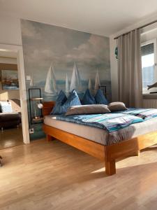 a bedroom with a bed with a painting of boats at Seewohnung Zentral in Millstatt +4 photos