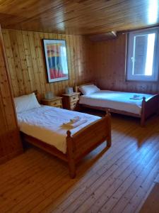 a bedroom with two beds in a wooden cabin at Nash Apartment in Saint-Jean-d'Aulps