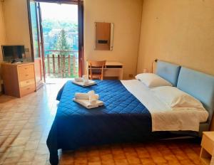 a bedroom with a blue bed with towels on it at Hotel Monte Viglio in Filettino
