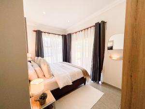 a bedroom with a bed and a large window at The Halfway Homestead in Middelburg