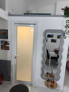 ein Zimmer mit einer Tür, einem Spiegel und einem Tisch in der Unterkunft Casa TeKa in Torre Annunziata