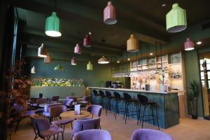ein Restaurant mit lila Stühlen und einer Bar in der Unterkunft Ghent Urbanist Hotel by Harmony in Gent