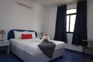 a bedroom with a white bed with red pillows and a window at Venus Bayahibe by Mireya in Bayahibe