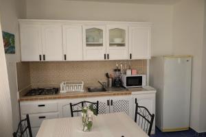 a kitchen with white cabinets and a table and a refrigerator at Venus Bayahibe by Mireya in Bayahibe +13 photos