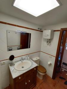 a bathroom with a sink and a toilet and a skylight at Sun Home Arinaga in Arinaga +45 photos