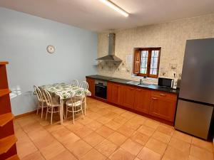 a kitchen with a table and chairs and a refrigerator at Rapia. Casa Rosa 2 in Moratalla