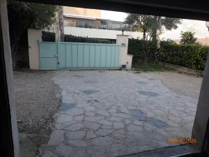 a driveway with a blue gate in front of a house at Chambre Privée avec Sauna in Villeneuve-Loubet
