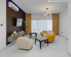 a living room with a couch and a chair at Luxury Balcony Apartment at THE HIDDEN DOMUS I Prestige Apartment in Accra