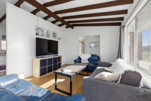 a living room with blue couches and a tv at Sea Gem in Lancelin