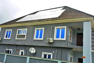 a house with a solar panel on top of it at 21 Suites & Apartments in Mama