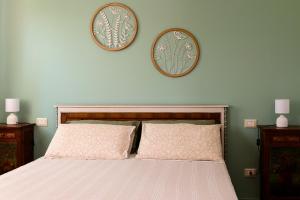 a bedroom with a bed with two plates on the wall at B&B Lilla All'Adige in Legnago
