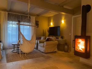 a living room with a hammock in front of a fireplace at FeWo Naturgeflüster - Mecklenburger Outback - Garten & Kamin - Private Sauna in Zölkow