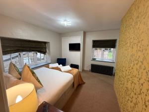 a bedroom with two beds and two windows at The Old Mill Inn in Bedford
