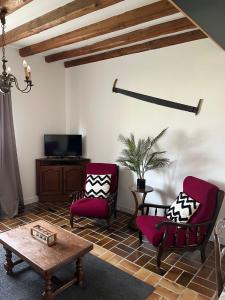 a living room with two chairs and a coffee table at Gîte de la Rouge Roye in Nompatelize