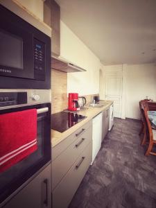 a kitchen with white cabinets and a stove top oven at Le Chalet du 1er étage, Appartement de charme de 80m2, 2 chambres in Bagnoles de l'Orne