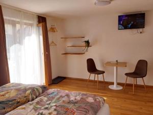 a bedroom with a bed and two chairs and a table at Haus Lorang in Pfronten