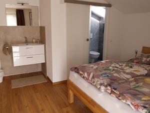 a bedroom with a bed and a bathroom with a sink at Haus Lorang in Pfronten