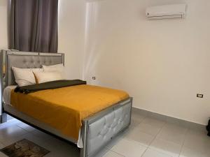 a bedroom with a bed with a yellow blanket on it at Simon Vip Complete Villa in Punta Cana