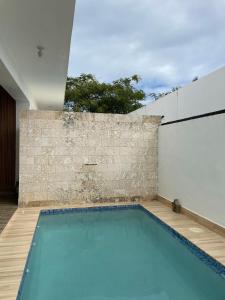 an indoor swimming pool with a brick wall at Simon Vip Complete Villa in Punta Cana