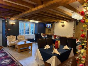 a restaurant with tables and chairs in a room at The Old Mill Inn in Bedford