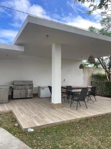 a patio with a table and chairs and a grill at Simon Vip Complete Villa in Punta Cana