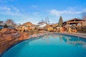a large swimming pool in a yard with a house at Timber & Tin D 2Bed 2Bath w Pool & Rooftop Deck in Kanab