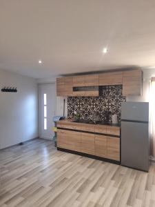 a kitchen with wooden cabinets and a refrigerator at L'escale du Chemin des Dames in Cerny-en-Laonnois