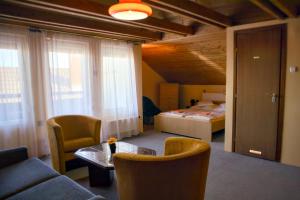 a living room with a couch and a bed at Fehérló Vendégház & Restaurant in Bük