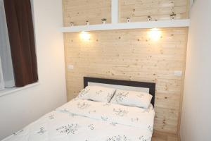 un letto in una stanza con una parete di legno di MiM LUX a Gornji Milanovac