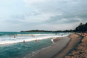 a group of people in the water at a beach at The Dream Bay in Arugam Bay
