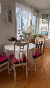 a dining room with a white table and chairs at Dahlias Bed & Breakfast in Väderstad