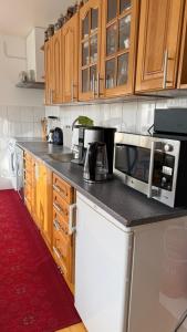 a kitchen with wooden cabinets and a microwave at Dahlias Bed & Breakfast in Väderstad +8 photos