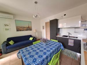 a living room with a table and a blue couch at Casa Manzoni in Lenno